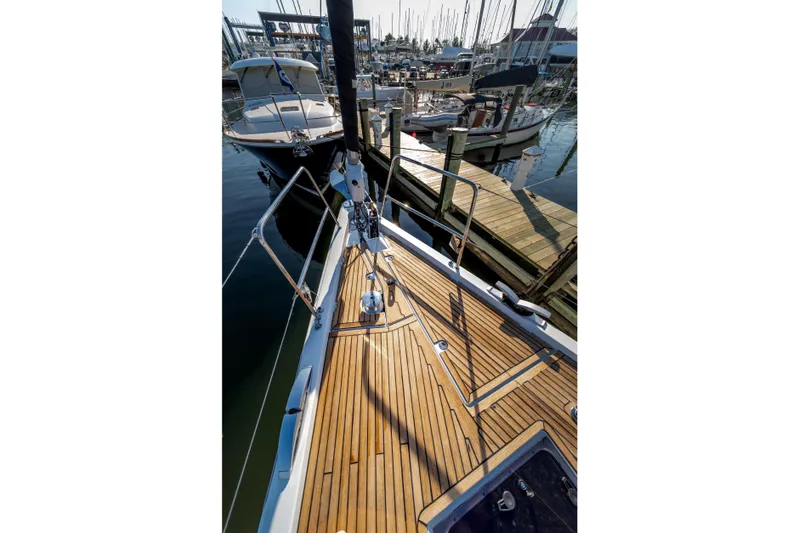 Serenity Yacht Photos Pics Jeanneau 64 sailboat deck, 2016 model, docked at marina with wooden finish.
