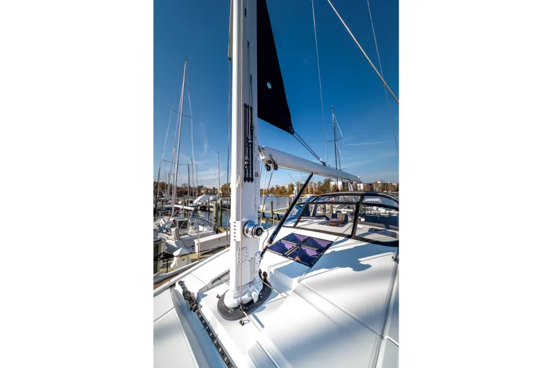 Serenity Yacht Photos Pics 2016 Jeanneau 64 sailboat deck with mast, docked in marina under clear blue sky.