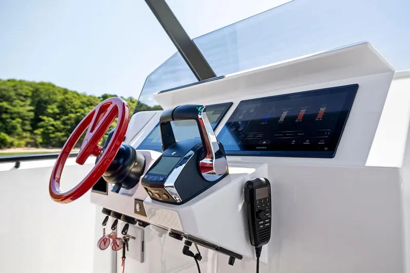Outrageous Yacht Photos Pics 2024 Vanquish Yachts VQ 40 helm station with modern controls and red steering wheel.