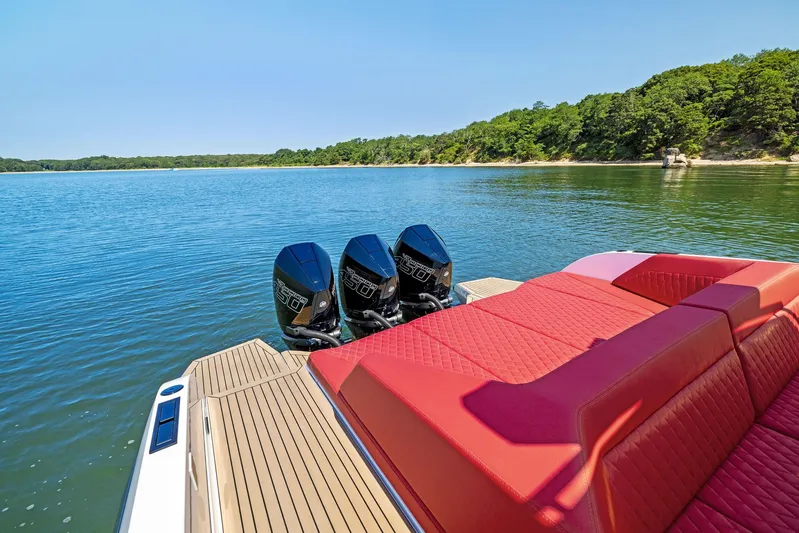 Outrageous Yacht Photos Pics 2024 Vanquish Yachts VQ 40 with triple outboard engines on a serene lake.