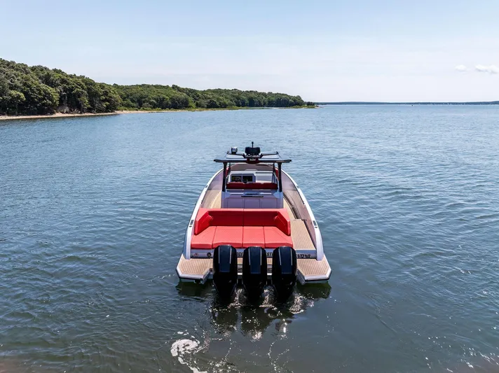 Outrageous Yacht Photos Pics 2024 Vanquish Yachts VQ 40 on serene water with lush green shoreline.