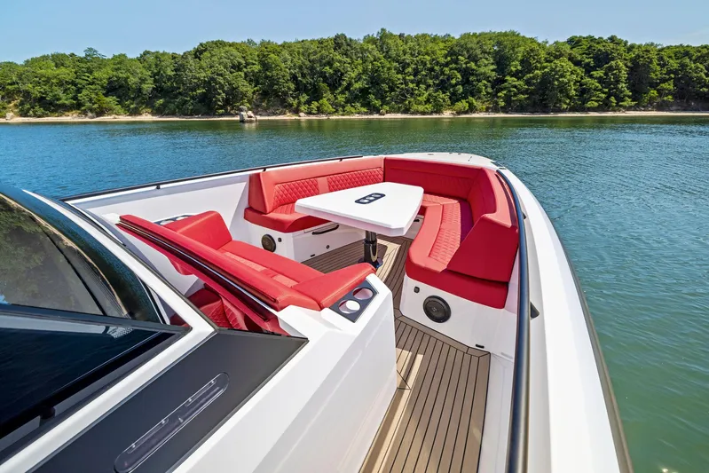 Outrageous Yacht Photos Pics 2024 Vanquish Yachts VQ 40 with red seating and table on a serene lake.