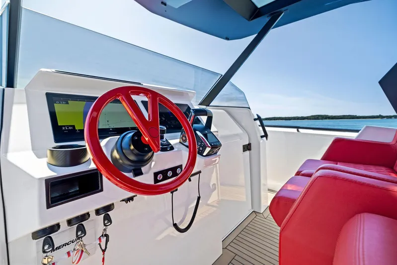 Outrageous Yacht Photos Pics 2024 Vanquish Yachts VQ 40 helm with red steering wheel and modern navigation system.