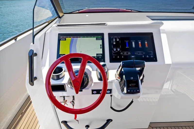 Outrageous Yacht Photos Pics 2024 Vanquish Yachts VQ 40 helm with red steering wheel and advanced navigation screens.