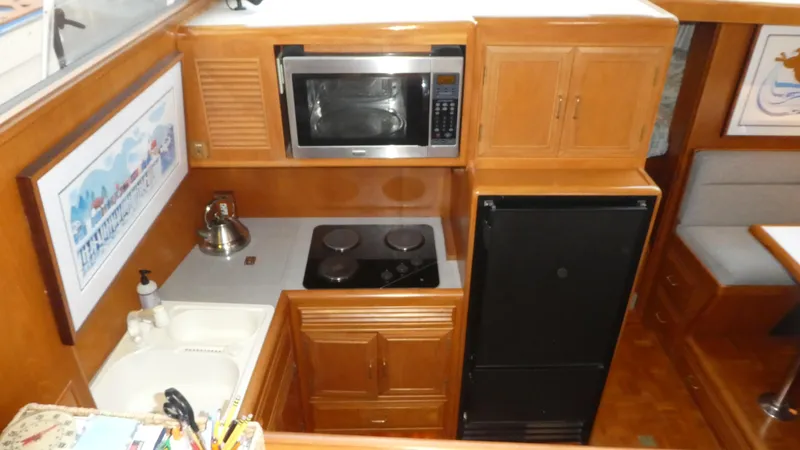 Morning Star Yacht Photos Pics 1993 Ocean Alexander 440 Sundeck CPMY galley with microwave, stove, and refrigerator.