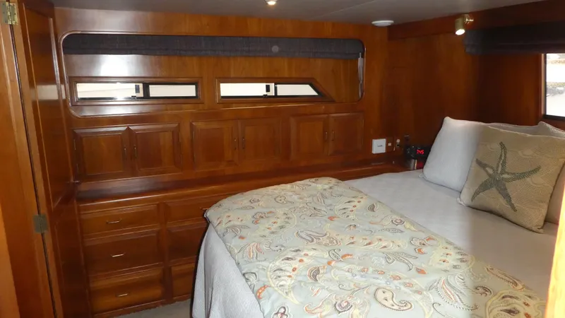 Morning Star Yacht Photos Pics 1993 Ocean Alexander 440 Sundeck CPMY cabin with wooden cabinetry and cozy bedding.