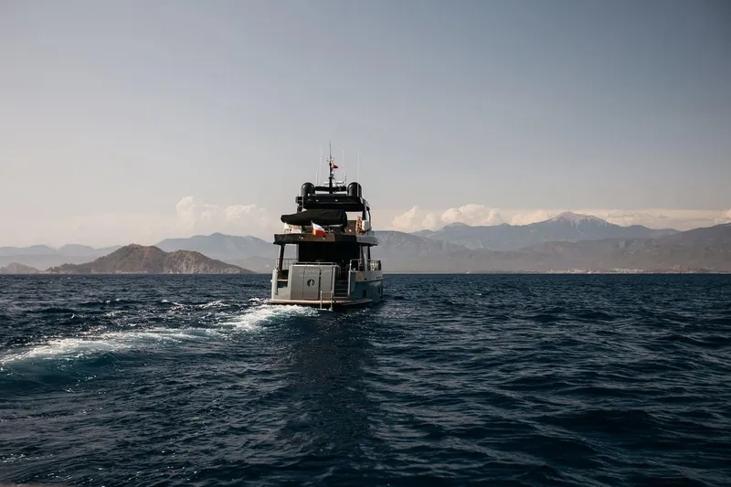  Yacht Photos Pics Bering 70 yacht cruising on open sea with mountainous backdrop, 2022 model.