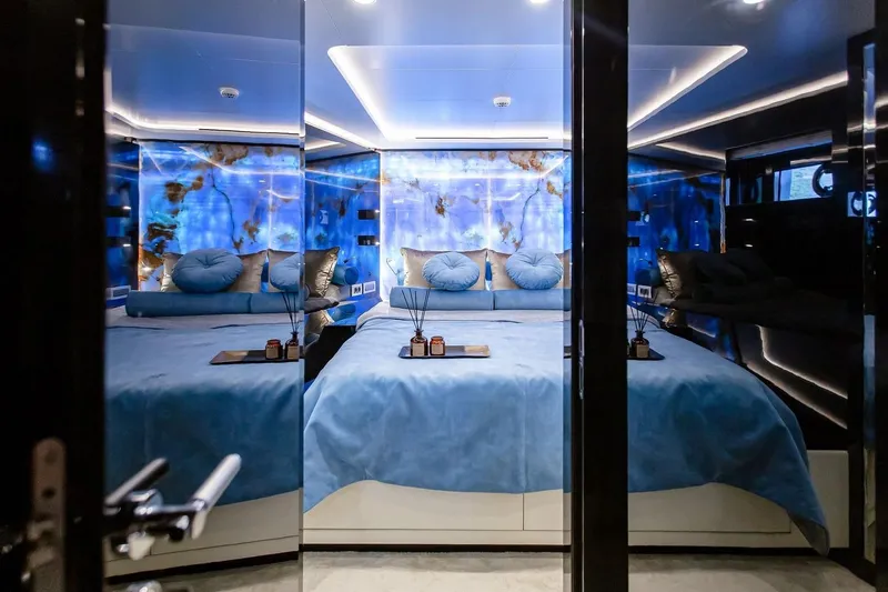  Yacht Photos Pics Luxurious bedroom interior on 2022 Bering 70 yacht with blue accents and modern design.