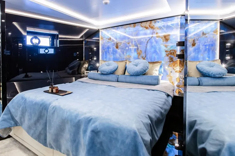  Yacht Photos Pics Luxurious 2022 Bering 70 yacht bedroom with elegant blue decor and ambient lighting.