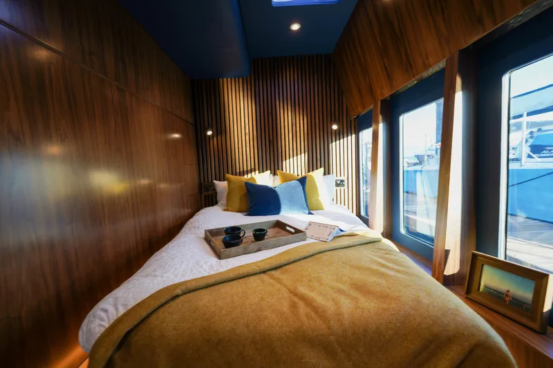  Yacht Photos Pics Luxurious bedroom in 2025 Archipelago 47 yacht with modern wood paneling and large windows.
