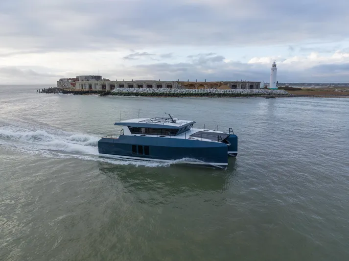 Yacht Photos Pics 2025 Archipelago 47 boat cruising near a lighthouse and coastal ruins.