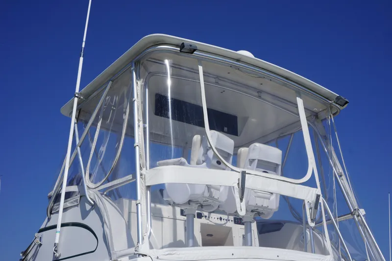 Musn't Touch It Yacht Photos Pics 1996 Egg Harbor 38 Sport Fish boat with clear enclosure against blue sky.
