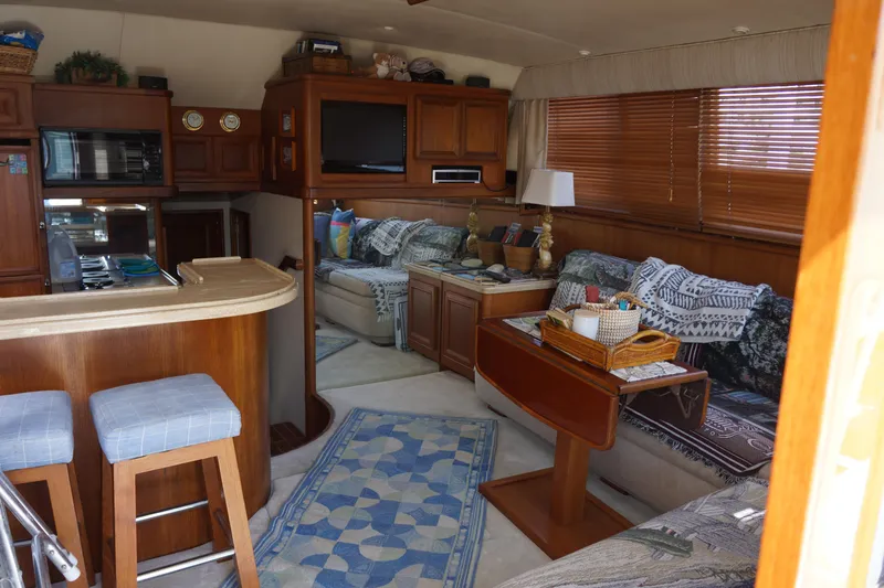 Musn't Touch It Yacht Photos Pics Interior of a 1996 Egg Harbor 38 Sport Fish yacht, featuring cozy seating and wooden cabinetry.