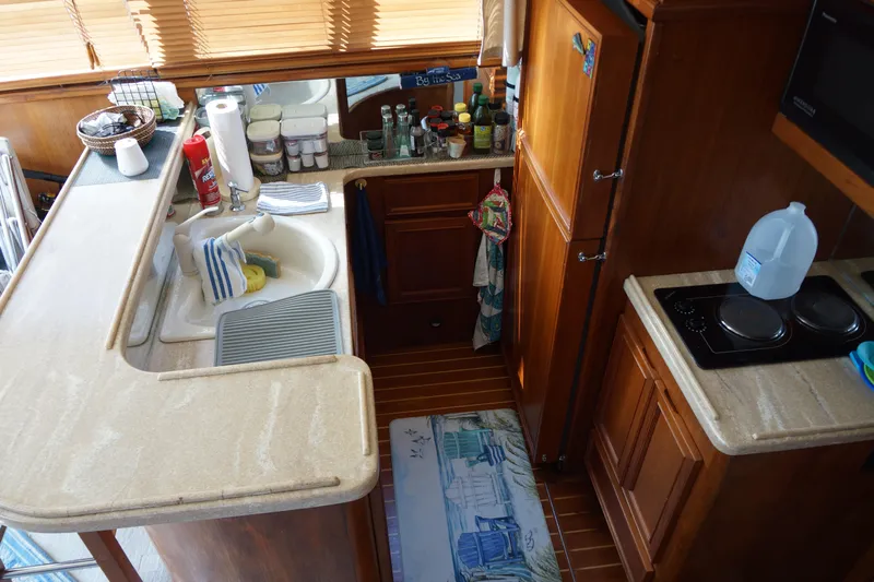 Musn't Touch It Yacht Photos Pics Interior of 1996 Egg Harbor 38 Sport Fish boat kitchen with wooden cabinetry and appliances.