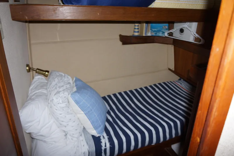 Musn't Touch It Yacht Photos Pics 1996 Egg Harbor 38 Sport Fish cabin with striped bedding and wooden accents.