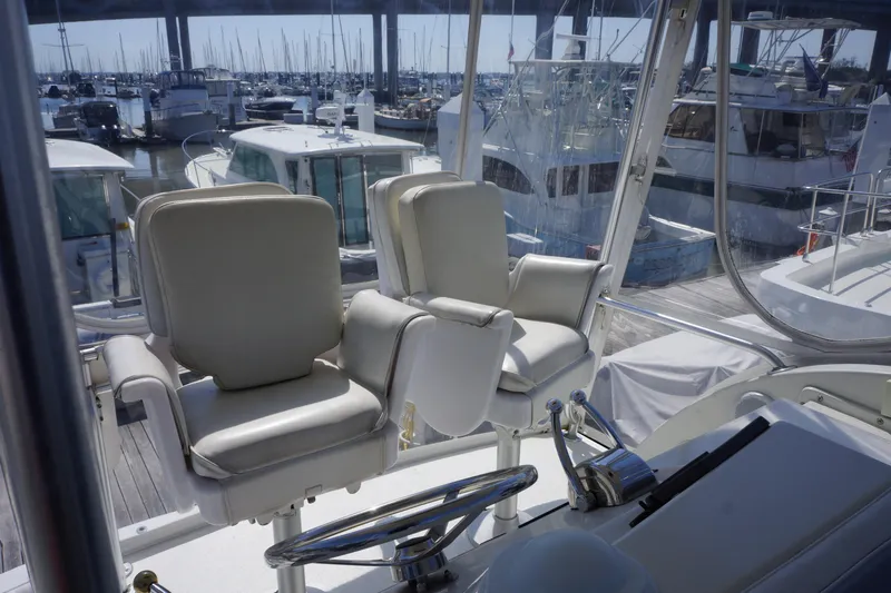 Musn't Touch It Yacht Photos Pics 1996 Egg Harbor 38 Sport Fish boat interior with helm chairs and marina view.