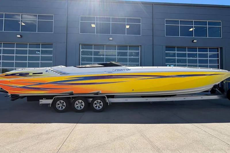  Yacht Photos Pics 2006 Fountain 42 Executioner speedboat with vibrant yellow and orange design on trailer.