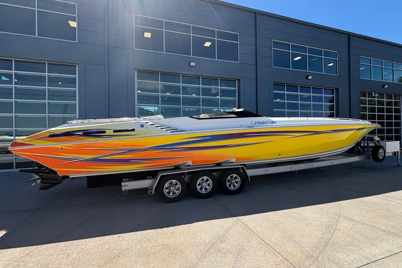  Yacht Photos Pics 2006 Fountain 42 Executioner speedboat with vibrant orange and yellow design on a trailer.