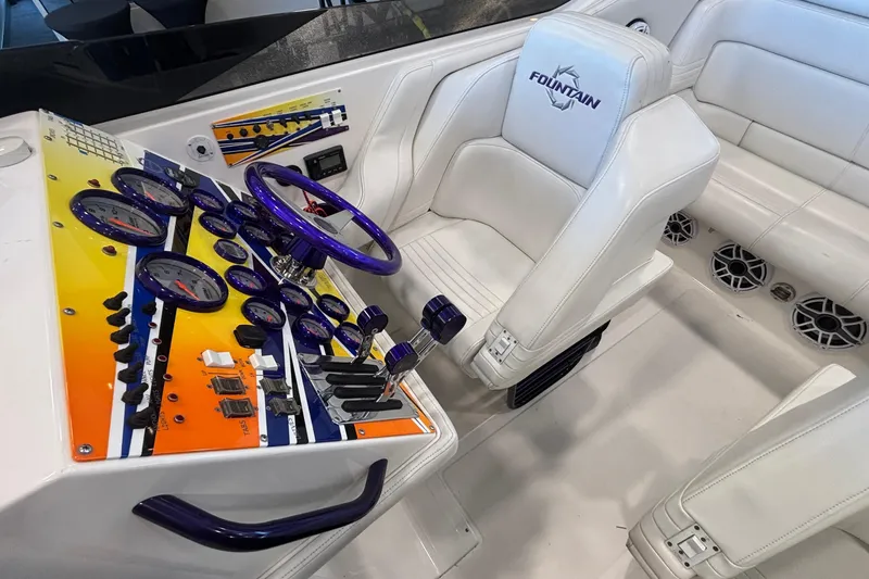  Yacht Photos Pics 2006 Fountain 42 Executioner boat cockpit with vibrant dashboard and white seating.