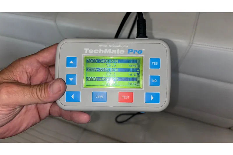  Yacht Photos Pics Hand holding TechMate Pro diagnostic tool displaying RPM hours for Fountain 42 Executioner boat.