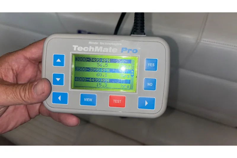  Yacht Photos Pics Hand holding TechMate Pro diagnostic tool displaying RPM data for 2006 Fountain 42 Executioner.
