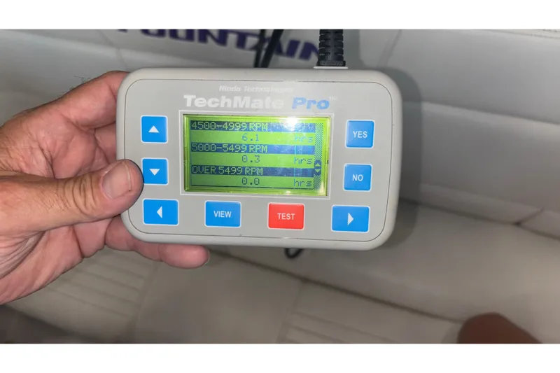  Yacht Photos Pics Hand holding TechMate Pro diagnostic tool displaying RPM data for Fountain 42 Executioner boat.