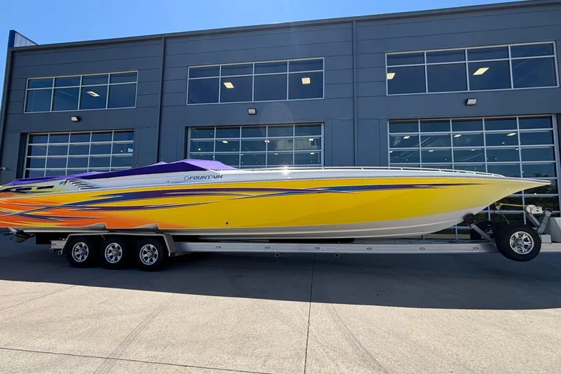  Yacht Photos Pics 2006 Fountain 42 Executioner speedboat with vibrant yellow and orange design on trailer.