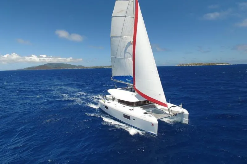 Pau Hana Yacht Photos Pics 2020 Lagoon 42 catamaran sailing on open blue ocean under clear skies.