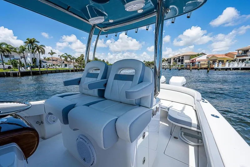  Yacht Photos Pics 2019 Mag Bay 33 CC boat interior with luxurious seating, set against a waterfront backdrop.
