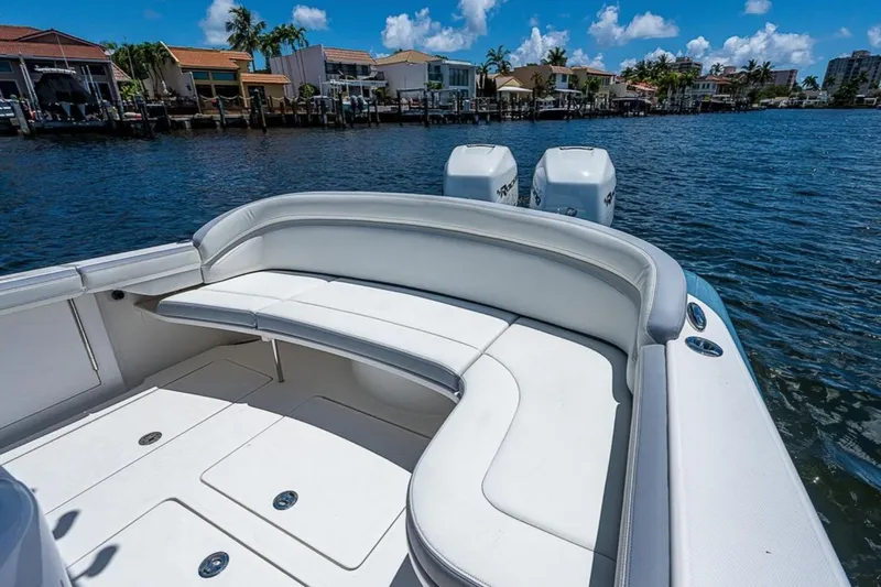  Yacht Photos Pics 2019 Mag Bay 33 CC boat with white seating, docked near waterfront homes.