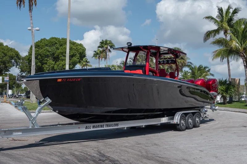  Yacht Photos Pics 2002 Midnight Express 39S Cuddy boat on trailer, sleek black design, palm trees in background.