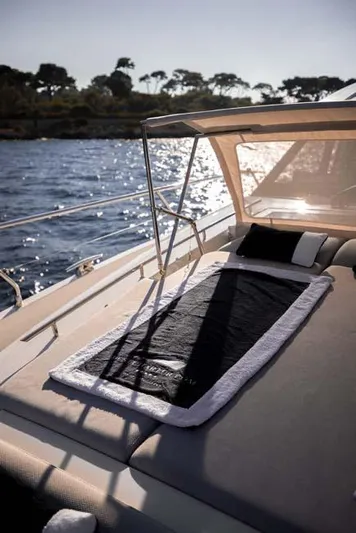  Yacht Photos Pics 2019 Prestige 680 S yacht deck with sunbed, overlooking serene waters and distant trees.