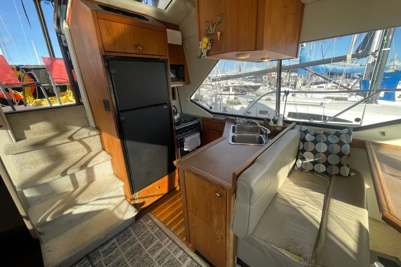 Happy Phantom Yacht Photos Pics 1996 Bayliner 4087 Aft Cabin Motoryacht interior with kitchen, seating, and marina view.