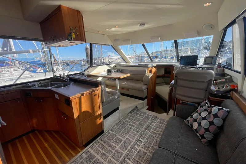 Happy Phantom Yacht Photos Pics 1996 Bayliner 4087 Aft Cabin Motoryacht interior with kitchen, seating, and helm station.