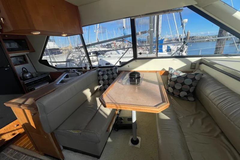 Happy Phantom Yacht Photos Pics Interior of 1996 Bayliner 4087 Aft Cabin Motoryacht with dining area and marina view.