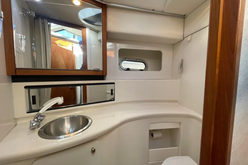 Happy Phantom Yacht Photos Pics 1996 Bayliner 4087 Aft Cabin Motoryacht bathroom with sink, mirror, and porthole window.
