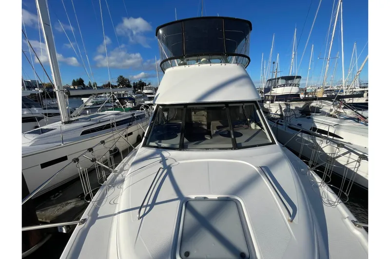 Happy Phantom Yacht Photos Pics 1996 Bayliner 4087 Aft Cabin Motoryacht docked among sailboats under a clear blue sky.