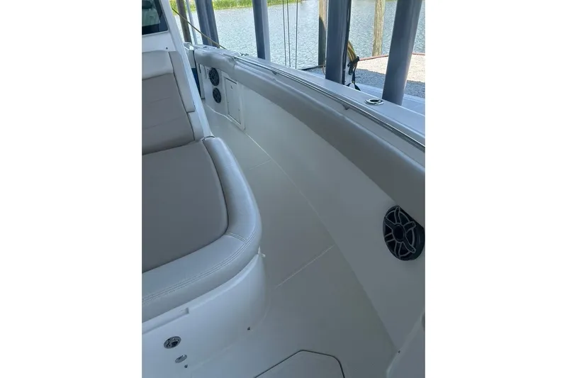  Yacht Photos Pics 2016 Boston Whaler 330 Outrage interior with seating and speaker, docked by water.