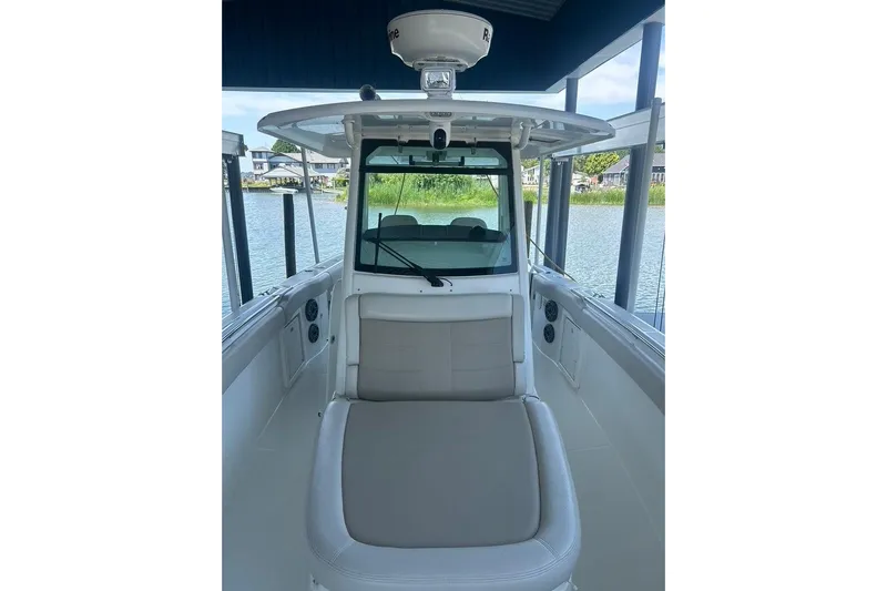  Yacht Photos Pics 2016 Boston Whaler 330 Outrage boat interior with seating, docked by the water.