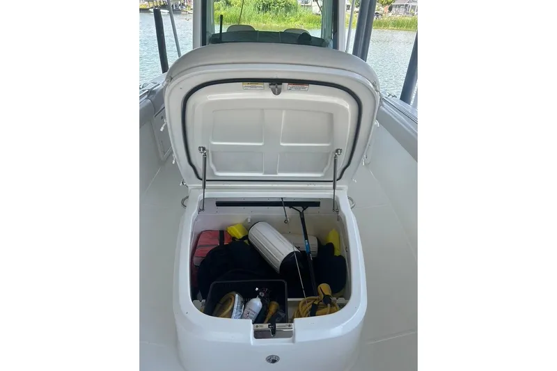  Yacht Photos Pics Open storage compartment on 2016 Boston Whaler 330 Outrage boat, containing various boating gear.