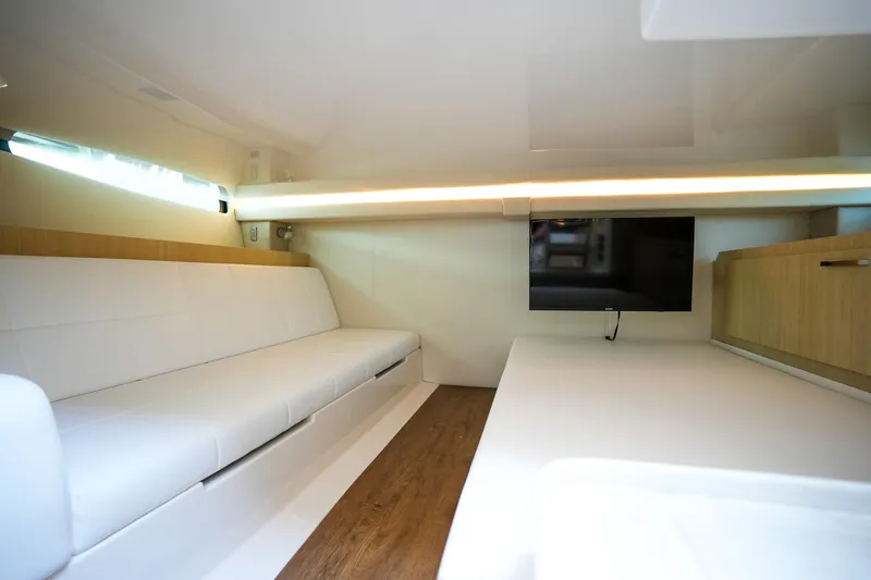  Yacht Photos Pics 2024 Regal 38 SAV interior with white seating, wood flooring, and wall-mounted TV.