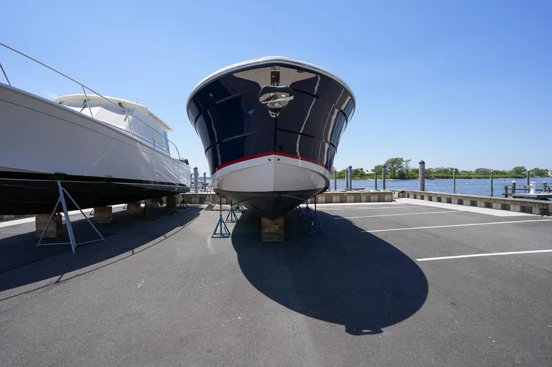  Yacht Photos Pics 2024 Regal 38 SAV boat on dry dock, sunny day, waterfront background.