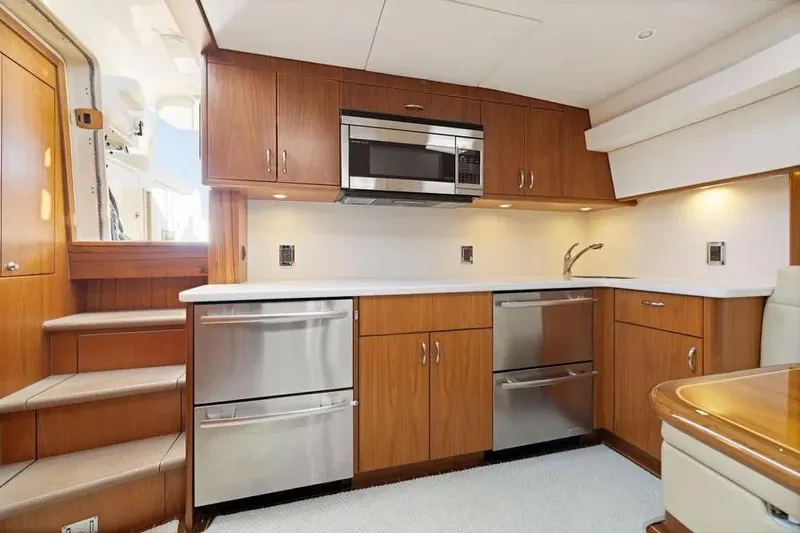  Yacht Photos Pics Luxurious 2012 Cabo 44 Hardtop Express yacht kitchen with modern appliances and wood cabinetry.