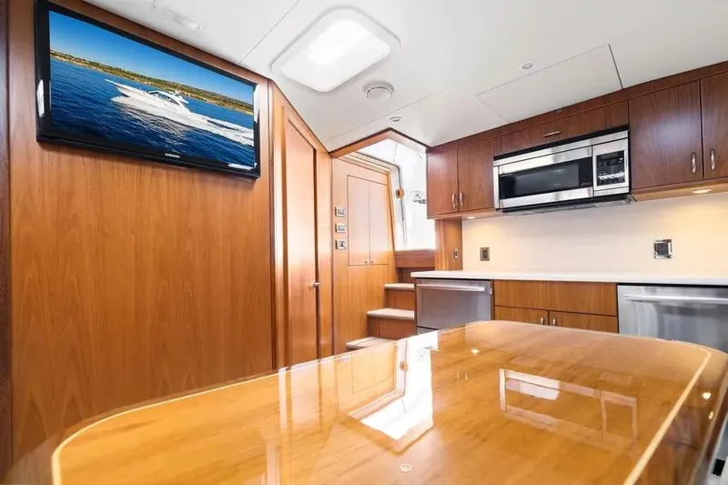  Yacht Photos Pics Luxurious interior of 2012 Cabo 44 Hardtop Express yacht with modern kitchen and TV.
