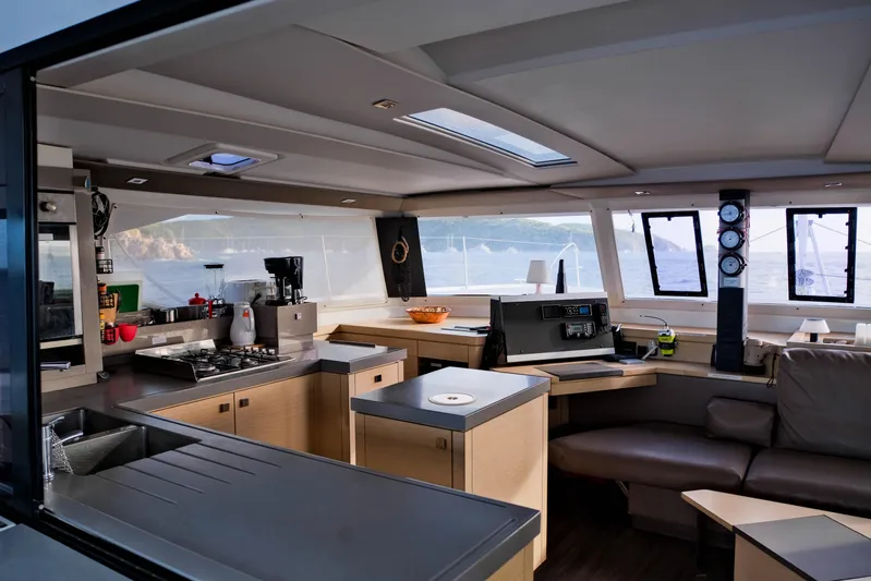 Long Story Yacht Photos Pics Luxurious interior of 2019 Fountaine Pajot Saona 47 catamaran with modern kitchen and navigation area.