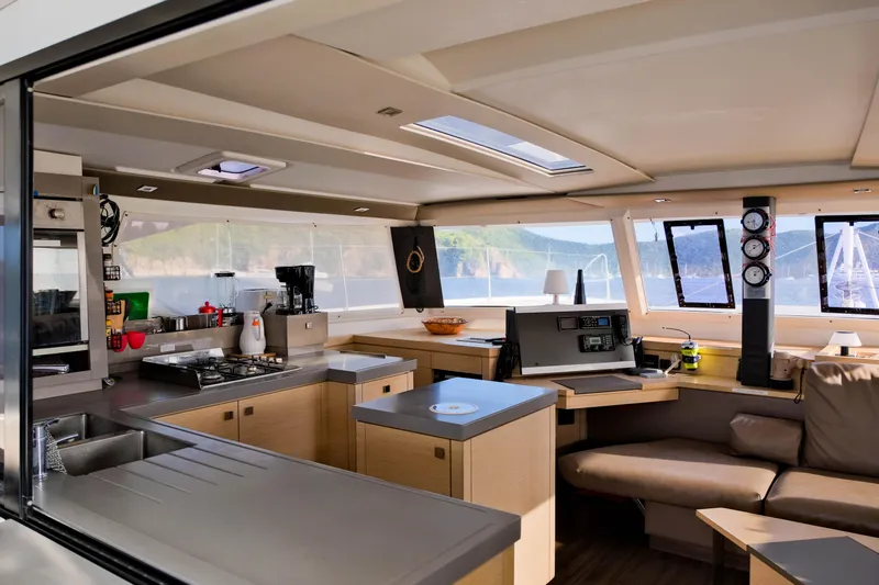 Long Story Yacht Photos Pics Luxurious interior of 2019 Fountaine Pajot Saona 47 catamaran with modern kitchen and navigation area.