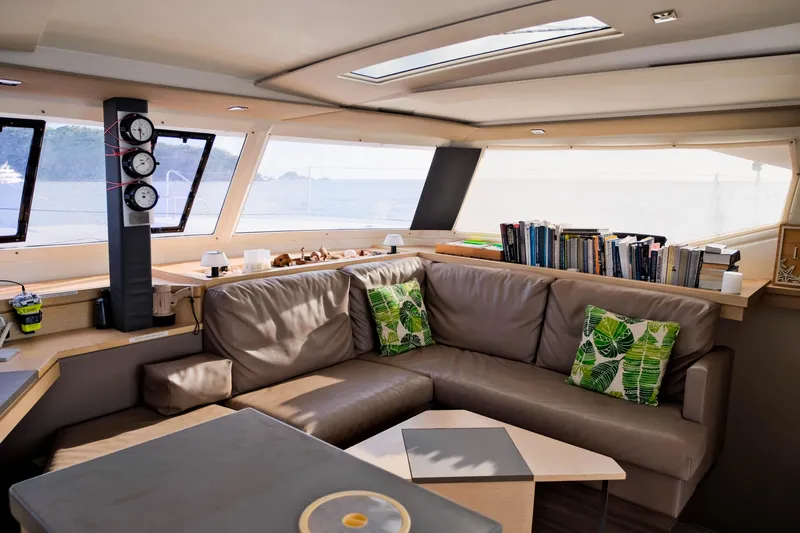 Long Story Yacht Photos Pics Luxurious interior of 2019 Fountaine Pajot Saona 47 catamaran with cozy seating and books.