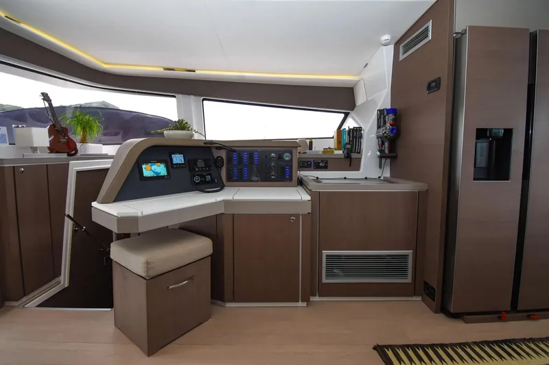 Nae Kae Yacht Photos Pics Modern interior of a 2022 Bali 5.4 yacht with navigation controls and kitchenette.