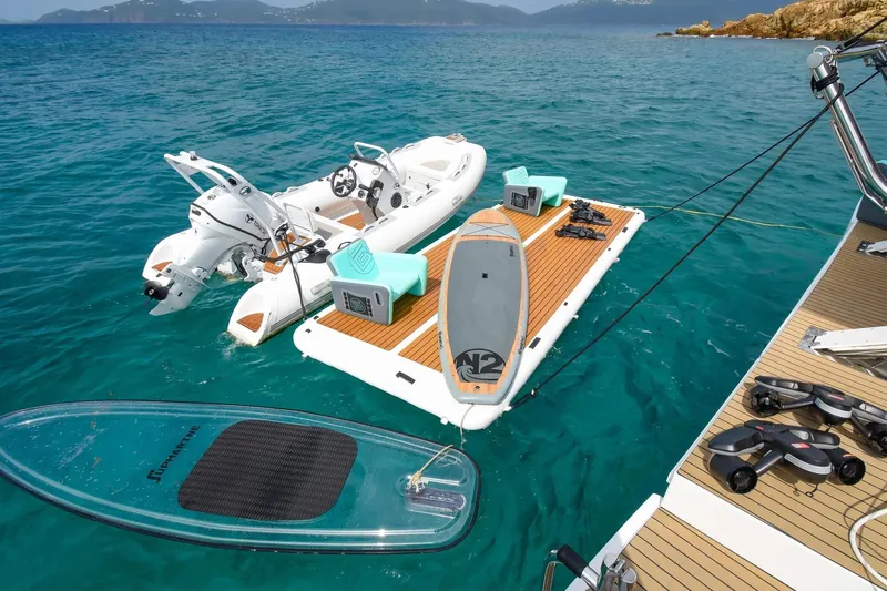 Nae Kae Yacht Photos Pics Floating dock with paddleboard and inflatable boat, Bali 5.4, 2022, in clear blue water.