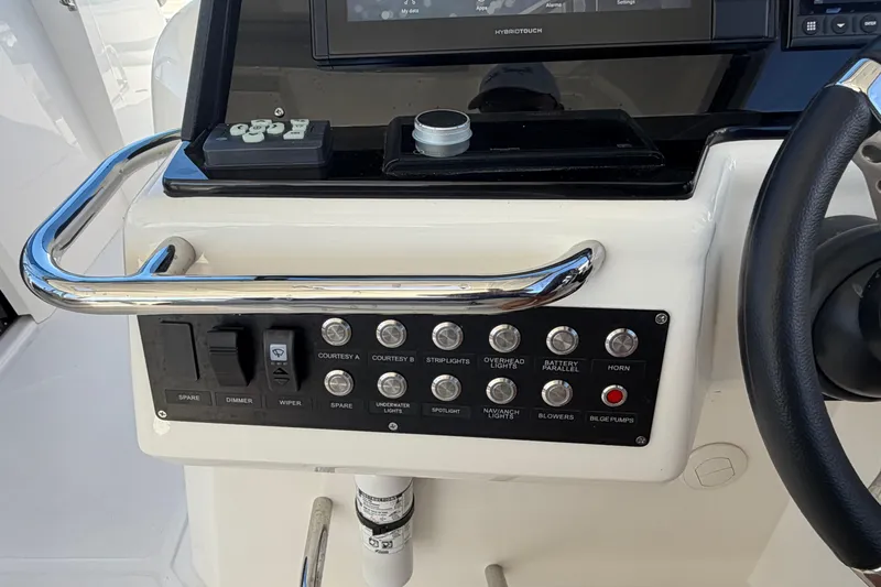 Chasin' Hyde Yacht Photos Pics Control panel of 2023 Aquila 36 Sport boat with various switches and steering wheel.